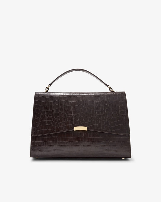 A dark brown crocodile-embossed leather handbag with a top handle and a gold-tone clasp, shown against a plain white background.