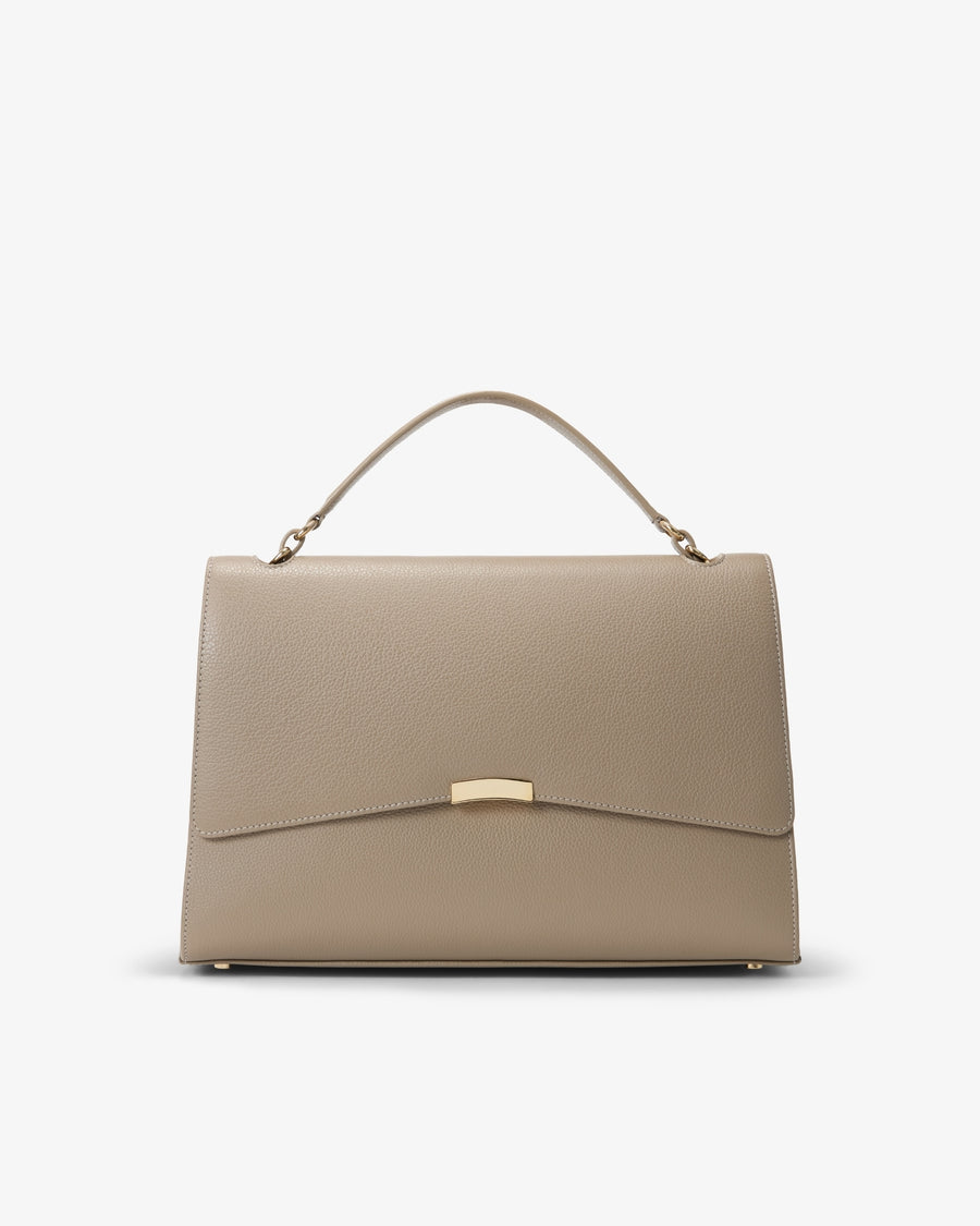A structured top-handle handbag in textured taupe leather with a gold-tone metal accent on the front flap, shown against a plain white background.