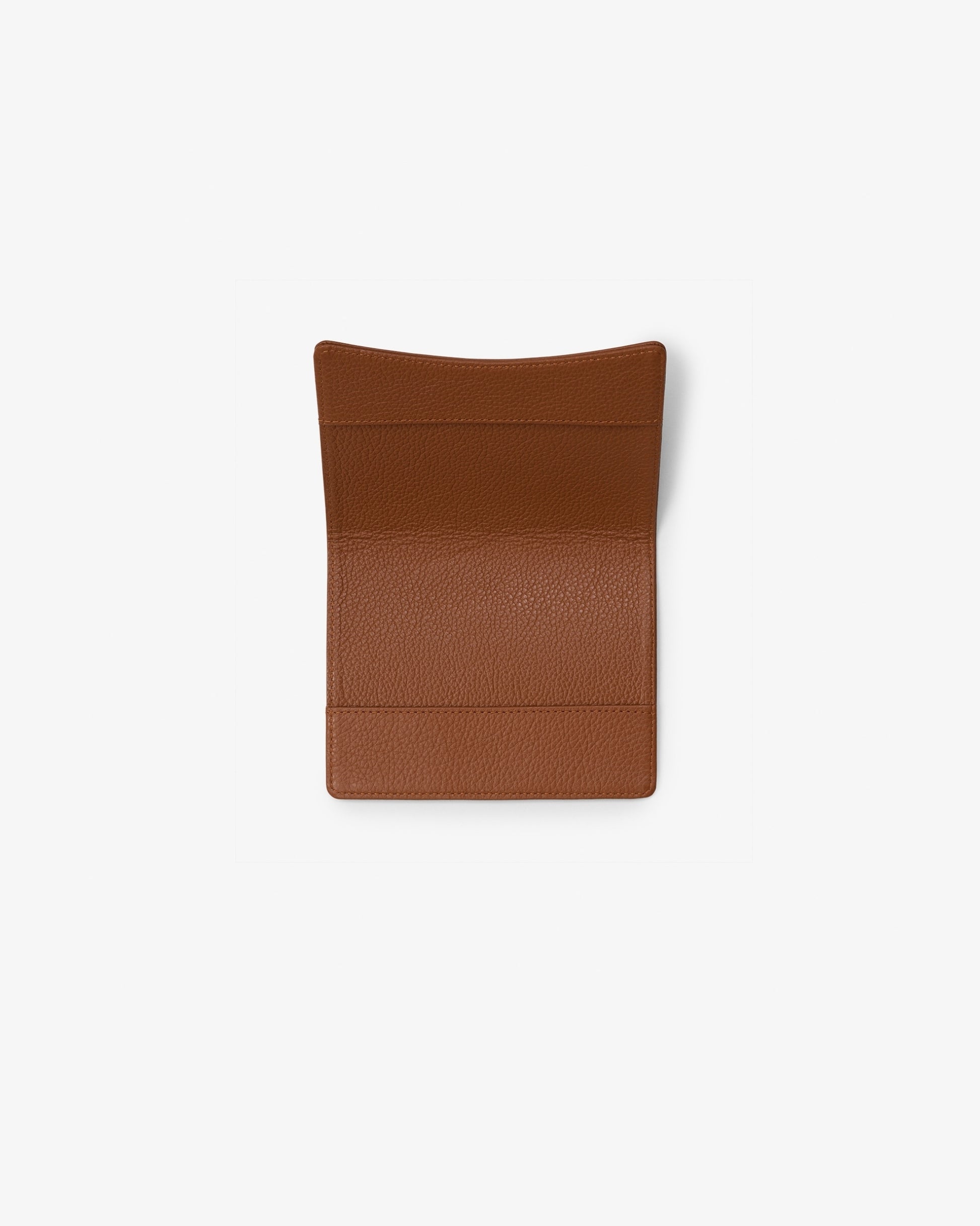 A brown textured leather passport holder or sleeve with a curved top edge, shown flat against a light gray background.