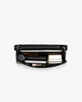A black leather bag shown open against a light gray background, revealing its interior storage compartments filled with various accessories.
