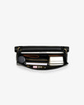 A black leather zippered briefcase shown open from a top-down view, revealing a silver metal lunchbox, a black circular item, and other small accessories inside, set against a plain white background.