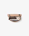 A top-down view of a light beige leather clutch bag with its flap open, showing a dark brown zippered pocket and a white patterned clutch inside, set against a plain light gray background.