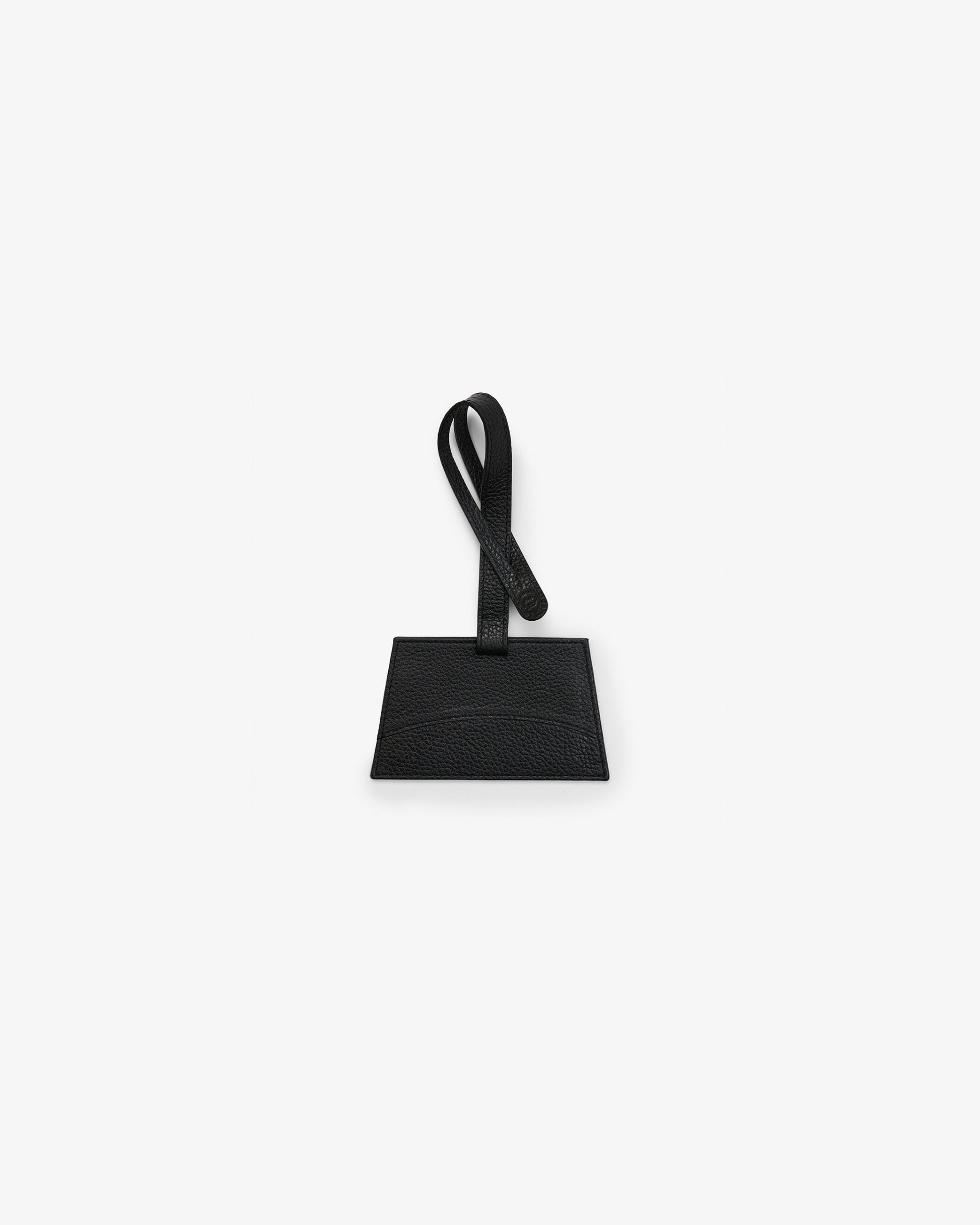 A black leather luggage tag with a rectangular body and a matching loop handle, shown against a plain white background.