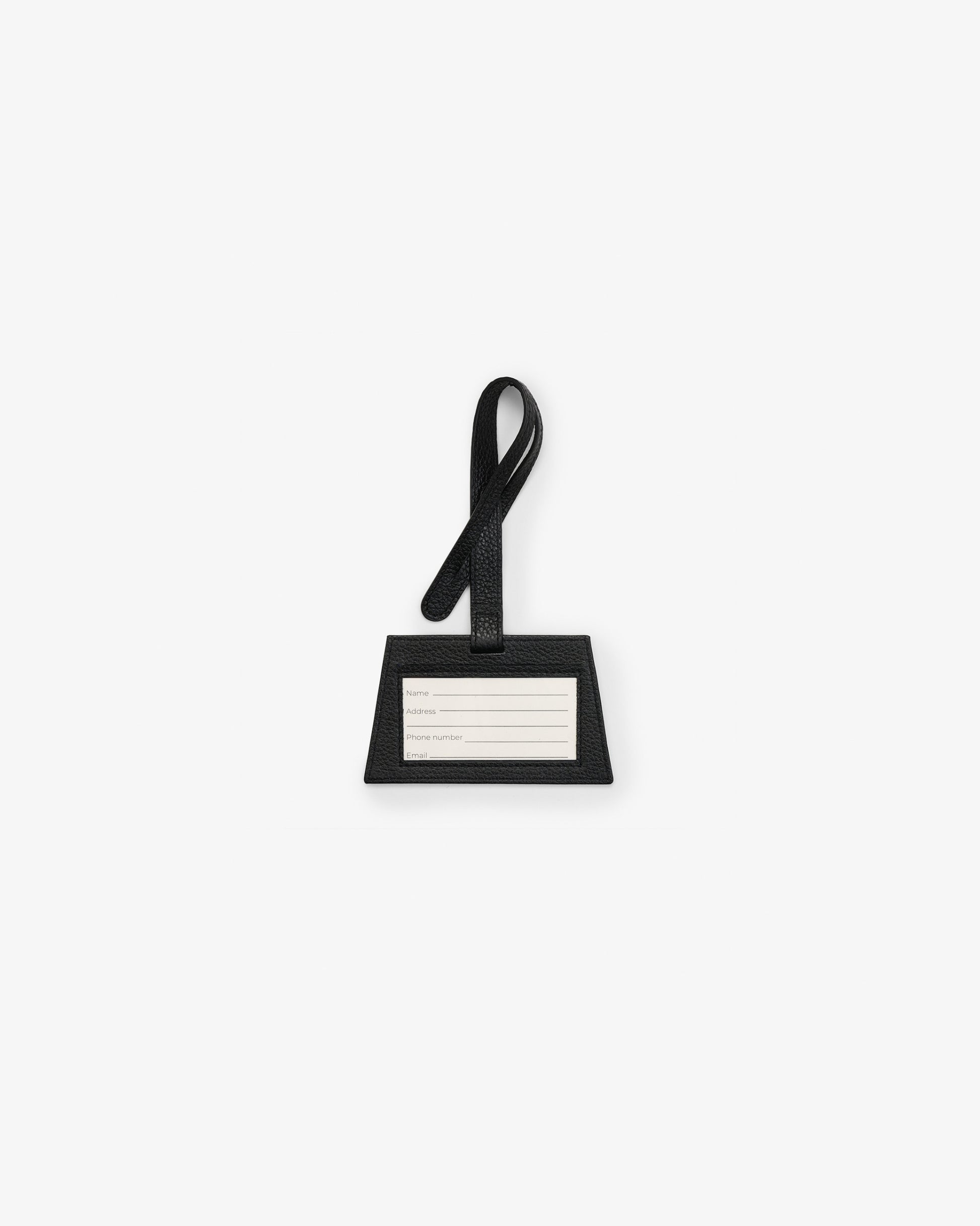 A minimalist black luggage tag with a loop handle and a white rectangular nameplate, centered on a light gray background.