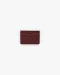 A dark burgundy textured leather card holder wallet, centered on a plain light gray background.