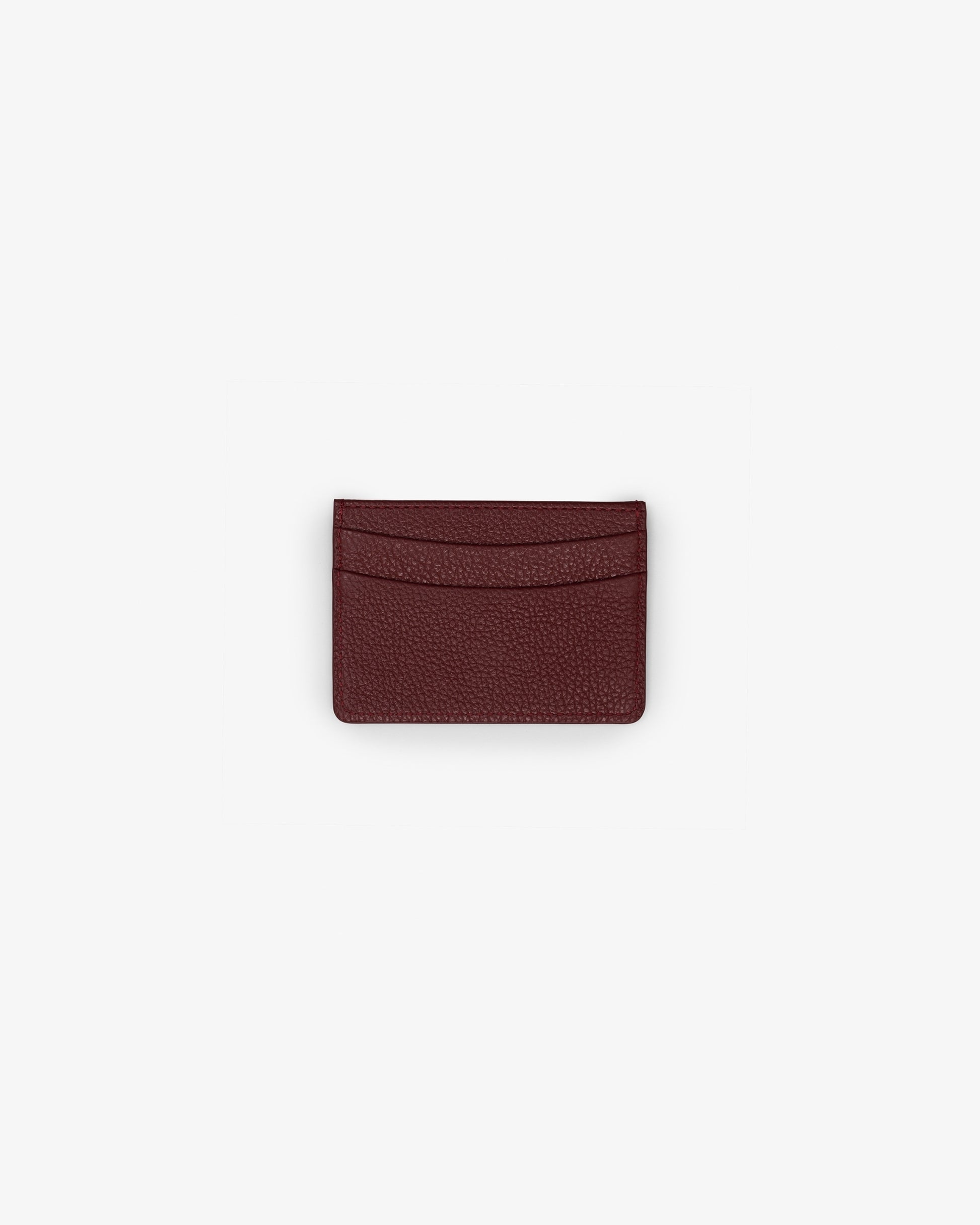 A dark burgundy textured leather card holder wallet, centered on a plain light gray background.