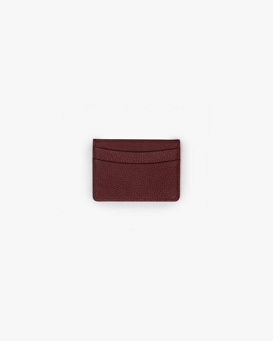 A dark burgundy textured leather card holder wallet, centered on a plain light gray background.