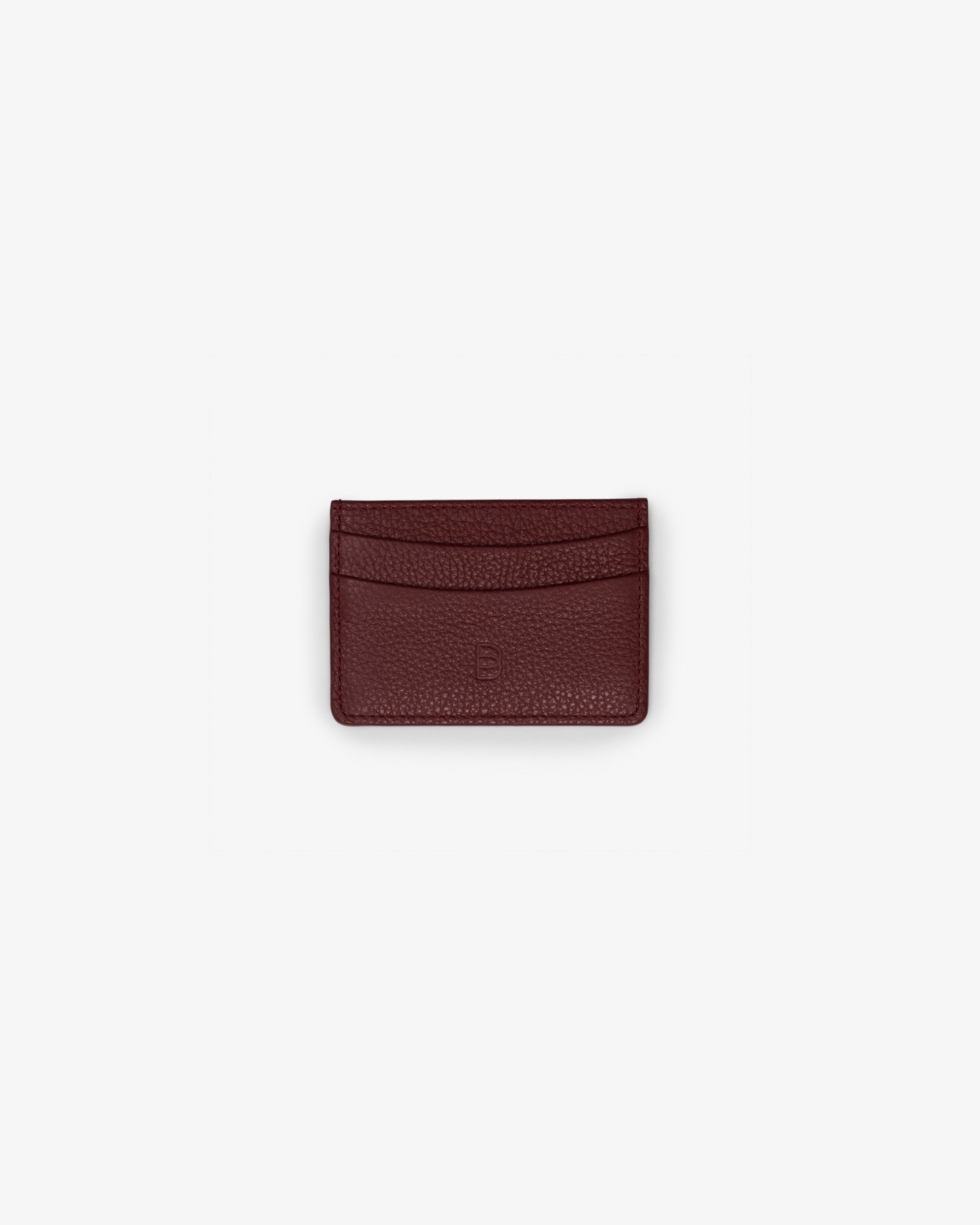 A small dark red textured leather card holder wallet centered on a light gray background.