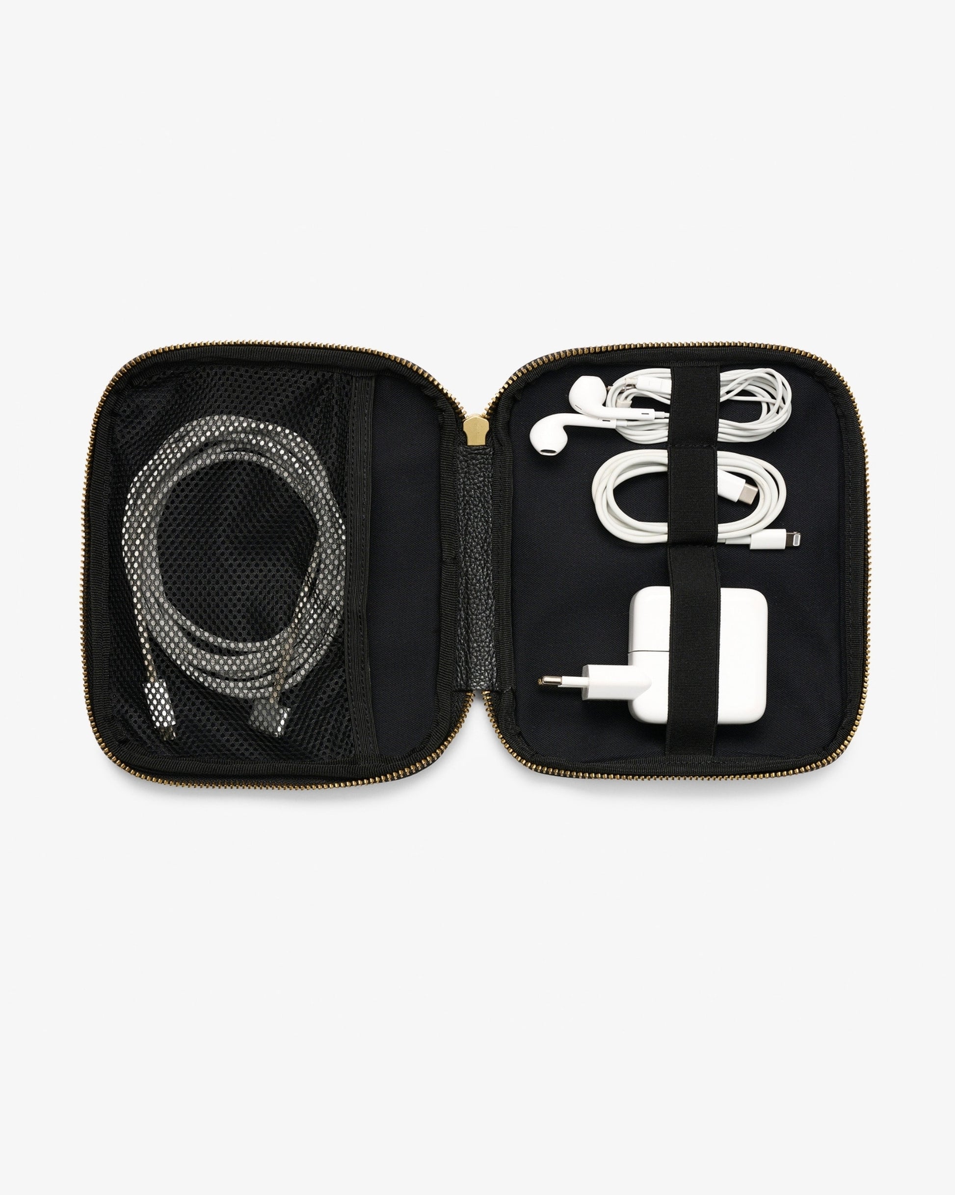 An open black zippered accessory organizer case with gold-tone zippers, shown on a light gray background. Inside, a gray braided charging cable is stored in a mesh pocket on the left, and a white earbud cable with a white charging adapter is secured by a black elastic band on the right.