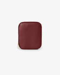 A small pebbled leather zip pouch in burgundy red, shown from the front on a clean white background.