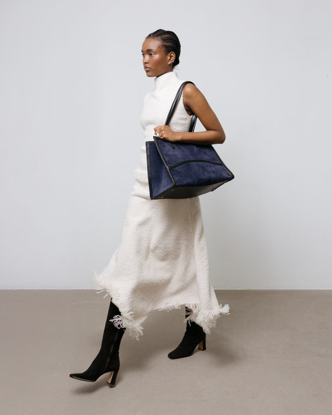 A navy blue suede tote bag with black leather trim and double shoulder straps, shown against a plain white background.