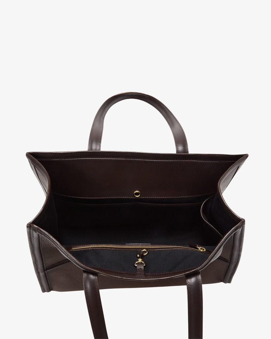 A dark brown leather tote bag shown from a top-down view, highlighting its spacious interior, dual top handles, and a zippered compartment with gold-tone hardware.