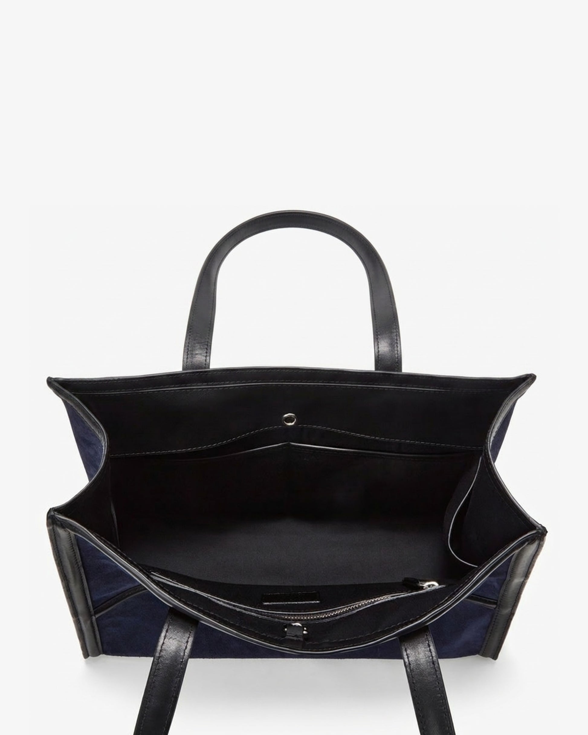 Top-down view of a structured tote bag with dark navy blue fabric body and black leather handles and trim, shown open against a plain white background.