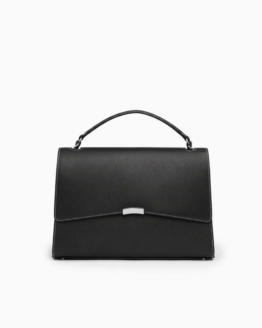 A black leather top-handle handbag with a flap closure, contrast stitching, and a small silver metal accent on the front, photographed against a plain white background.