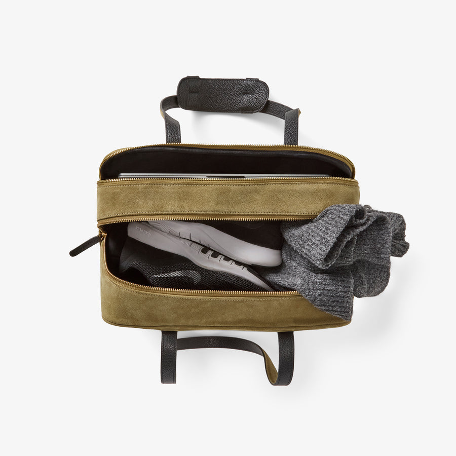 Top-down view of the 12 Hour Duffel Bag in Olive/Gold, packed with essentials including sneakers and a sweater, demonstrating its spacious dual-compartment design.