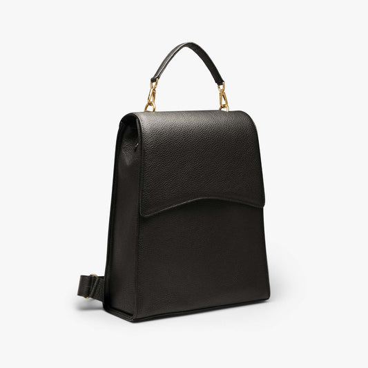 A black grained leather backpack with light gold metalware. It has a detachable top handle and adjustable shoulder straps. It fits your laptop and other daily essentials.