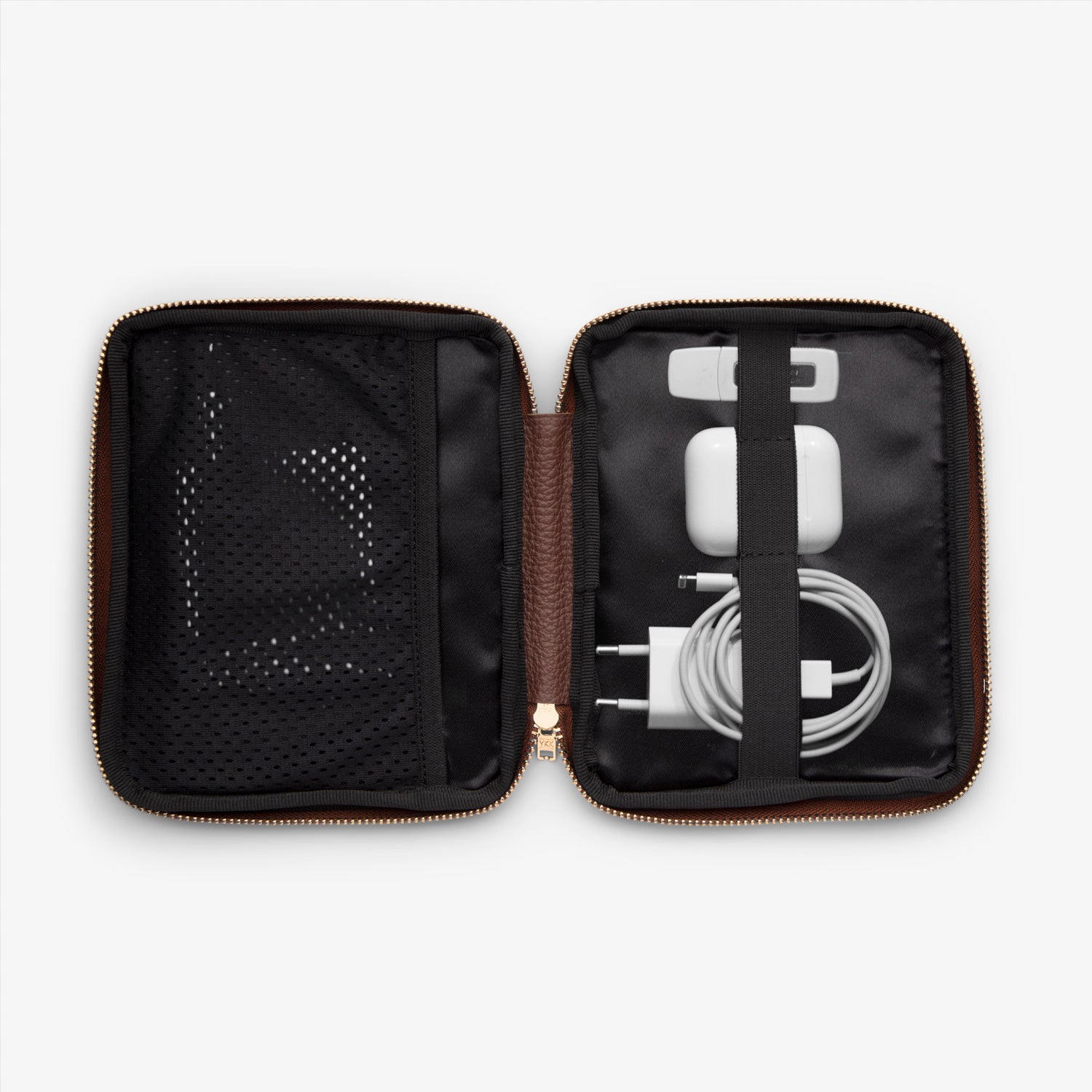Shows the inside of a cable pocket displaying AirPods, phone charger, and USB stick, all neatly arranged and organized for easy access while on the go.